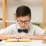 用戴著領結、戴著眼鏡的小男孩專心讀書的畫麵來表示正在高效地閱讀科學論文