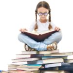 一張年輕女孩坐在一大堆書上的照片，膝上放著一本打開的書，這是提高文學調查水平的提示