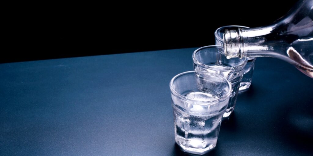 三個小酒杯和一個透明玻璃瓶，裏麵裝著透明的酒精液體，代表實驗室可以使用的乙醇等級